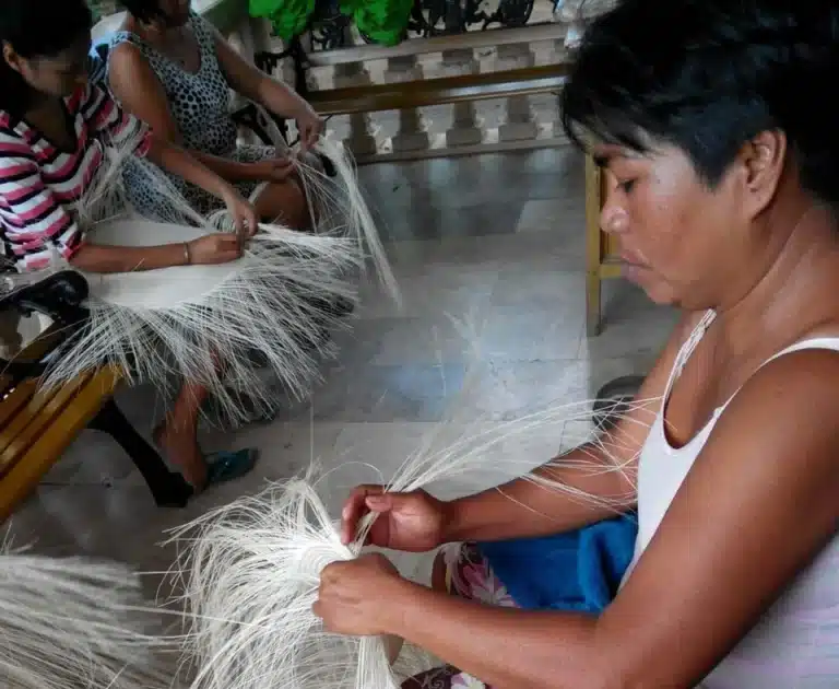 Local Filipino craftsmen hand-weaving traditional handicrafts using sustainable abaca and buri fibers for export.